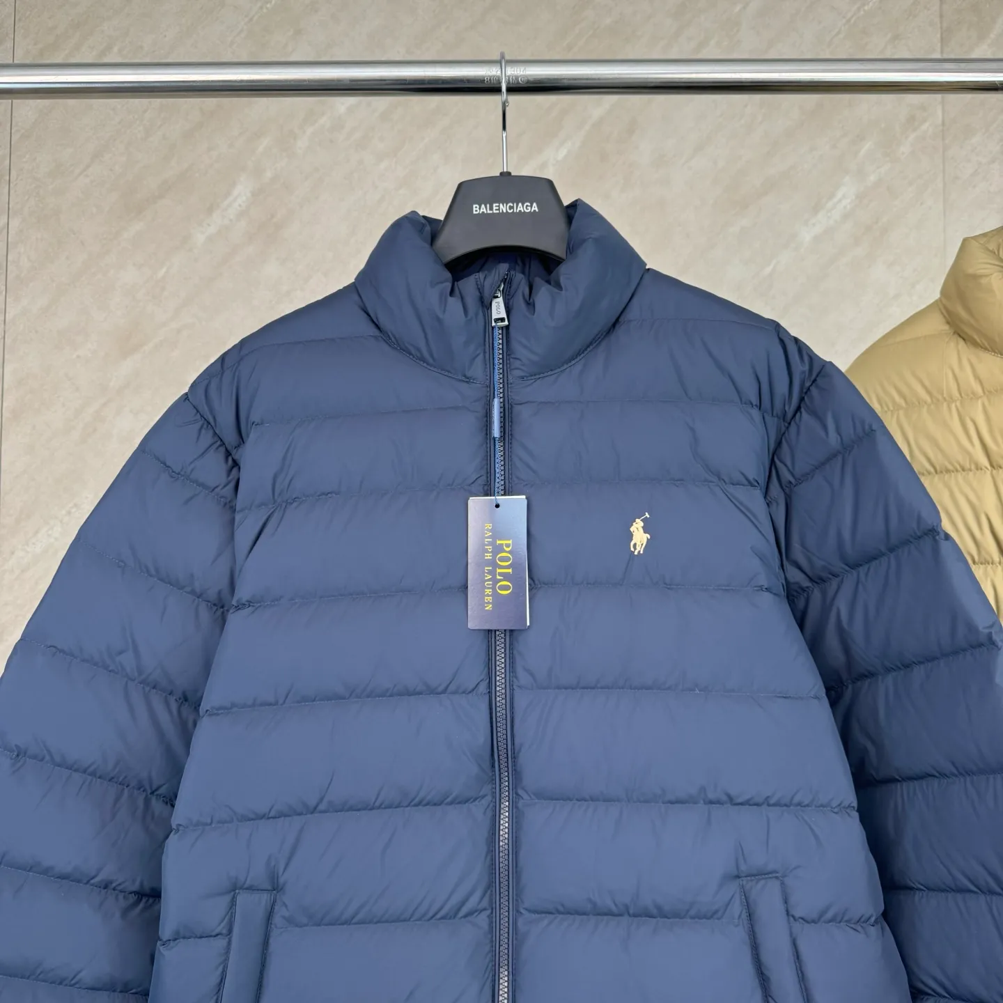 P930 lightweight down jacket size s m l xl Nylon fabric has good windproof and waterproof properties, which can effectively block the intrusion of wind and rain from the outside and keep the inside dry, suitable for wearing in humid or rainy environments.  The red label on the chest is made with an imported MECLO embroidery machine. The original pattern is scanned first, and then high-quality silk thread is used to make a pattern. The density effect is adjusted by continuous pattern making.  Exquisite details: the zipper design is simple and elegant, easy to operate; the closing design of the cuffs and hem effectively prevents the intrusion of cold wind, improving the warmth and comfort of wearing.  High-quality filling: 90 white duck down is selected, with a weight of 260g, ensuring excellent thermal insulation performance. After strict screening and processing, the velvet is not easy to drill, ensuring durability. The hangtags, wash marks, air holes, and four-button buttons are all customized from the original one-to-one mold.